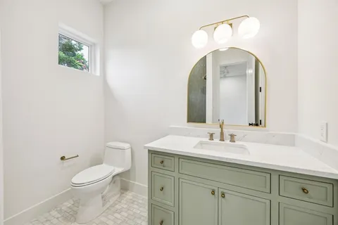 a bathroom with a toilet sink and mirror