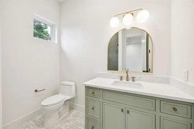 a bathroom with a toilet sink and mirror