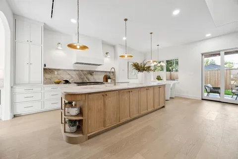 a kitchen with stainless steel appliances granite countertop a sink a stove and a wooden floors