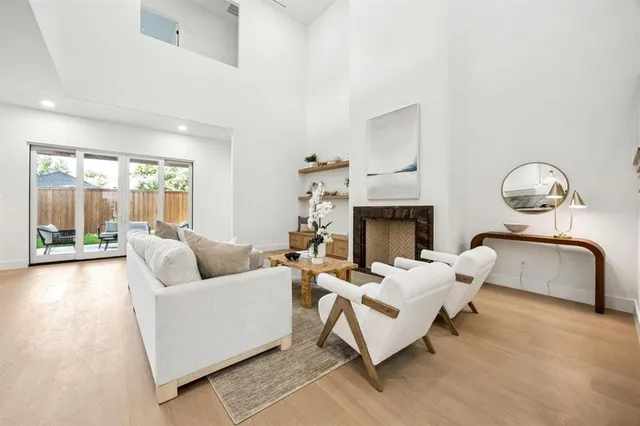 a living room with furniture a fireplace and a large window