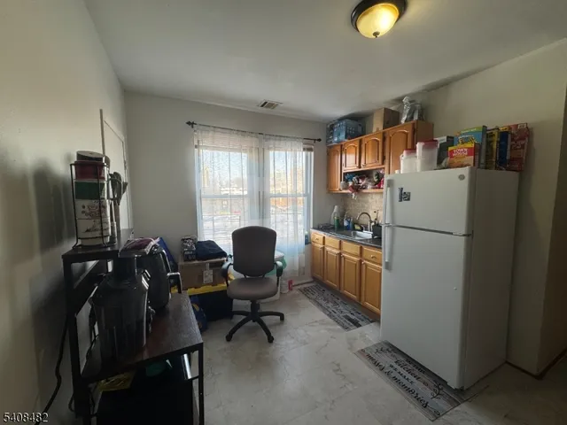 a kitchen with a refrigerator coffee maker on the counter top