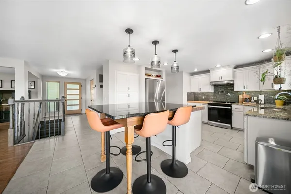 a kitchen with stainless steel appliances kitchen island granite countertop a sink and cabinets