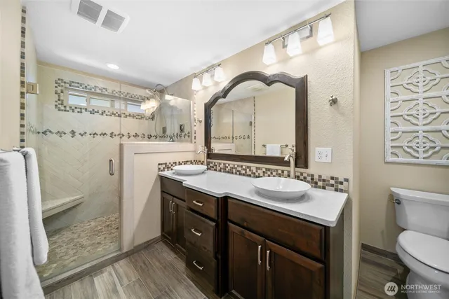 a bathroom with a granite countertop sink mirror vanity and toilet