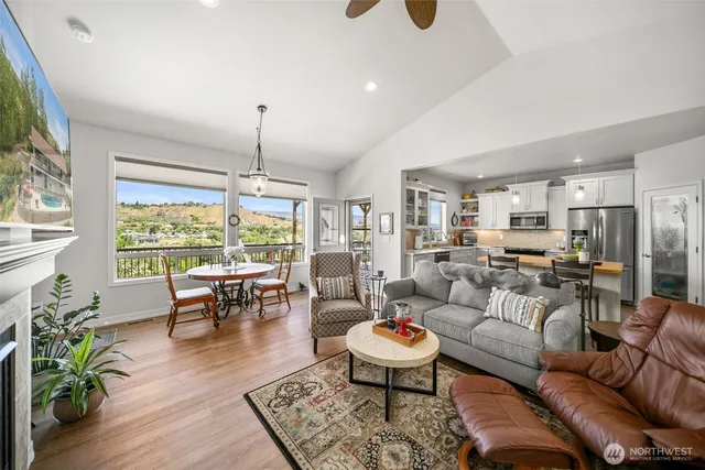 a living room with furniture kitchen view and large windows