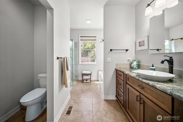 a spacious bathroom with a granite countertop sink toilet and shower