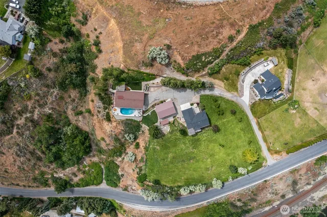 an aerial view of residential house with outdoor space and trees all around