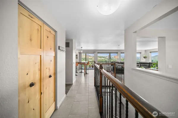 a view of a hallway with wooden floor and windows