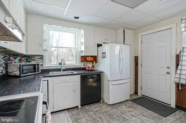 a kitchen with granite countertop a refrigerator stove and sink