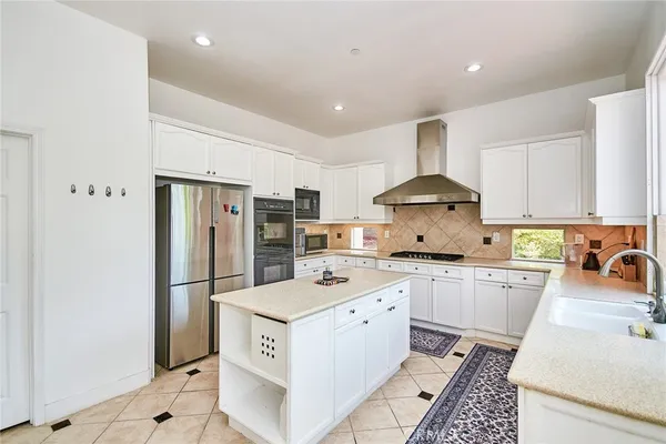 a kitchen with a sink a refrigerator a stove a washer dryer and cabinets