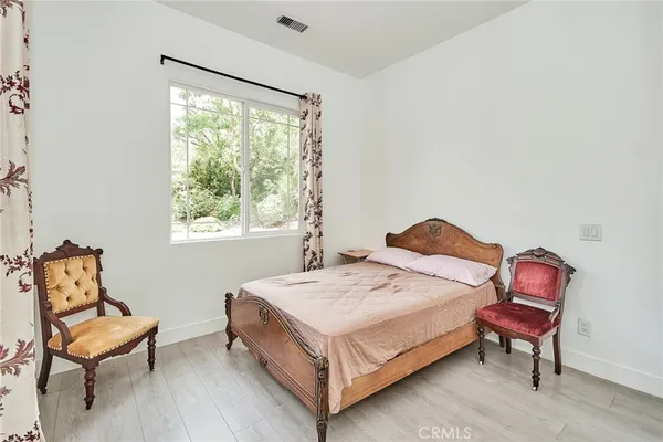 a bedroom with a bed chair and a window