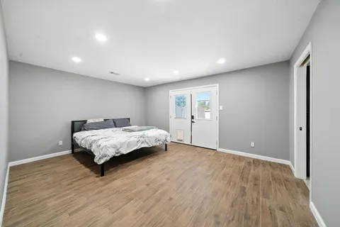 a bedroom with a bed and a wooden floor