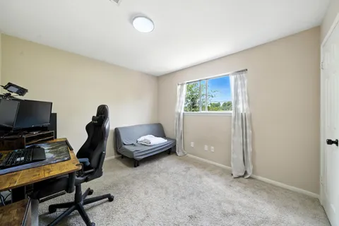 a view of a workspace with furniture and a window