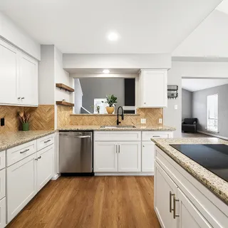 a kitchen with granite countertop white cabinets and white appliances