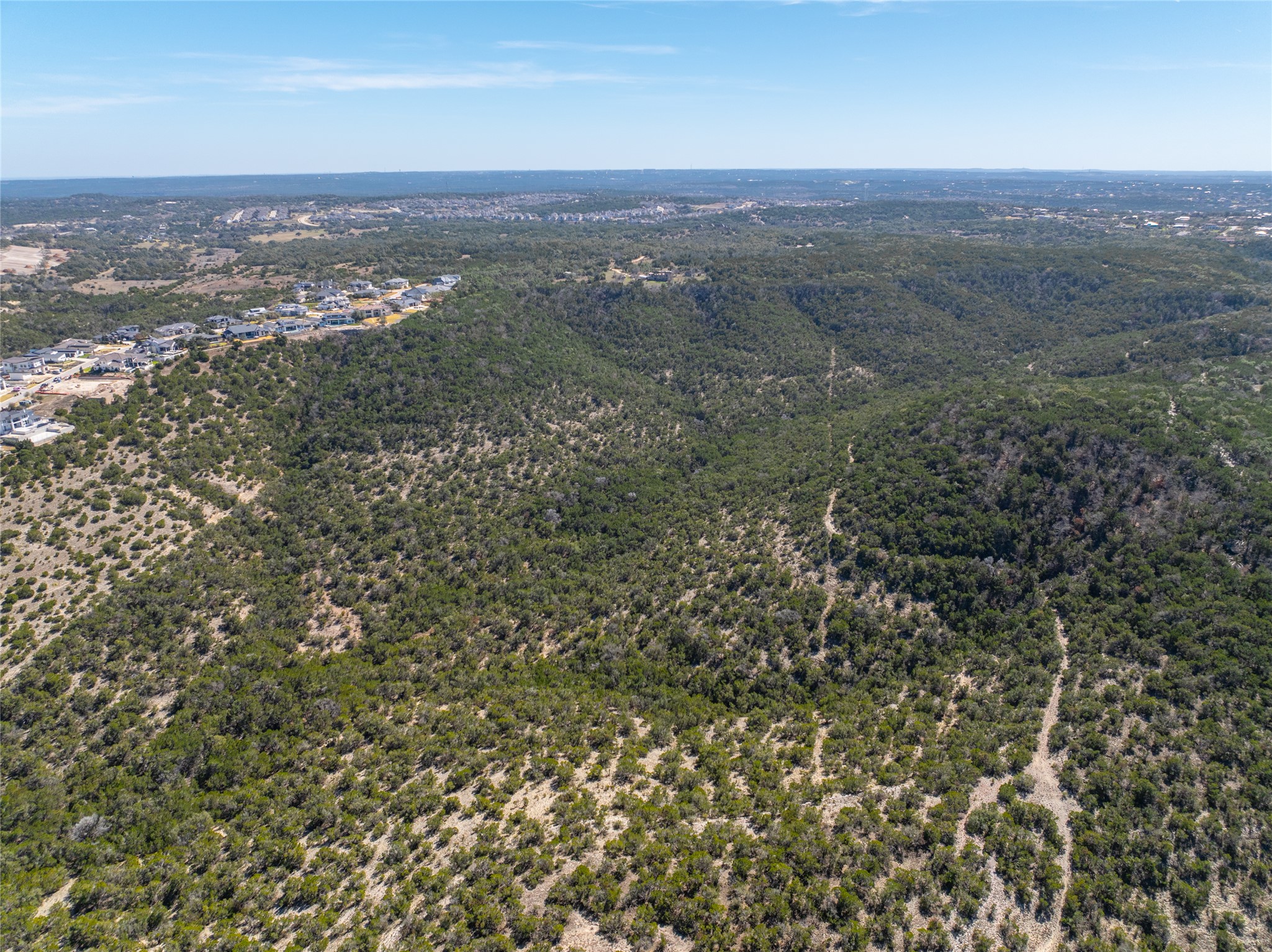 17318 Hamilton Pool Road Austin, TX 78738 - Photo 15 of 21 Rolling green hills stretch toward the horizon under a clear blue sky.
