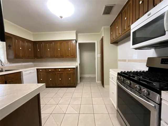 a kitchen with a stove a sink and a microwave