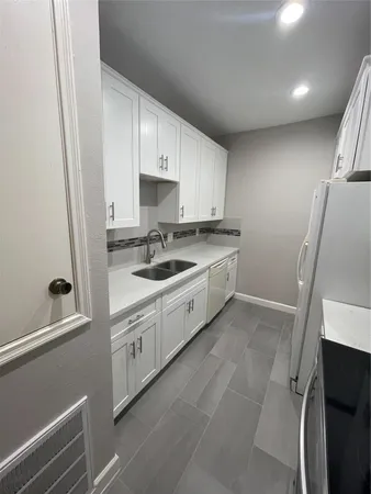 a kitchen with a sink a stove and cabinets