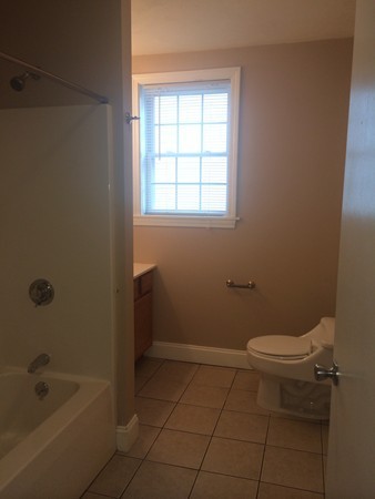 186 Diman Street Fall River, MA 02721 - Photo 3 of 6 a bathroom with a granite countertop toilet a sink and bathtub