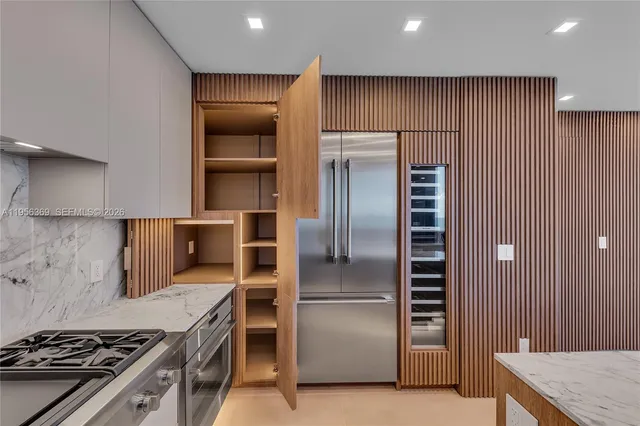 a large kitchen with wooden floor and large windows