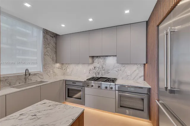 a kitchen with stainless steel appliances granite countertop a sink stove and refrigerator
