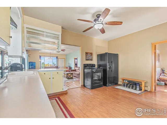 a kitchen with stainless steel appliances kitchen island granite countertop a stove a sink a dining table and chairs with wooden floor