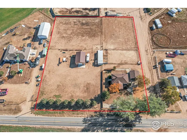 a view of a yard in front of a house with a large tree