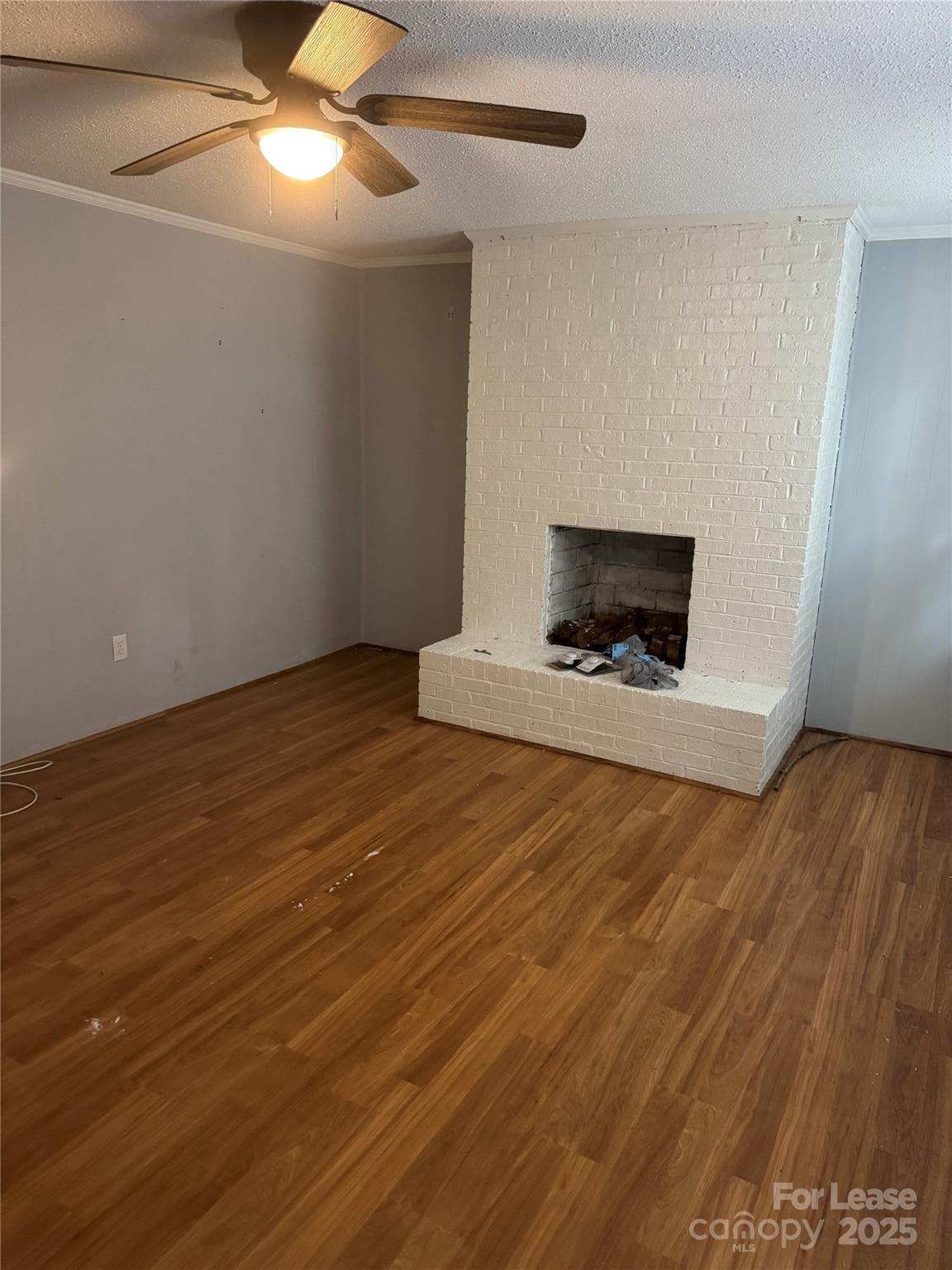 112 Chaney Street Wingate, NC 28174 - Photo 2 of 7 a view of an empty room with wooden floor and a fireplace