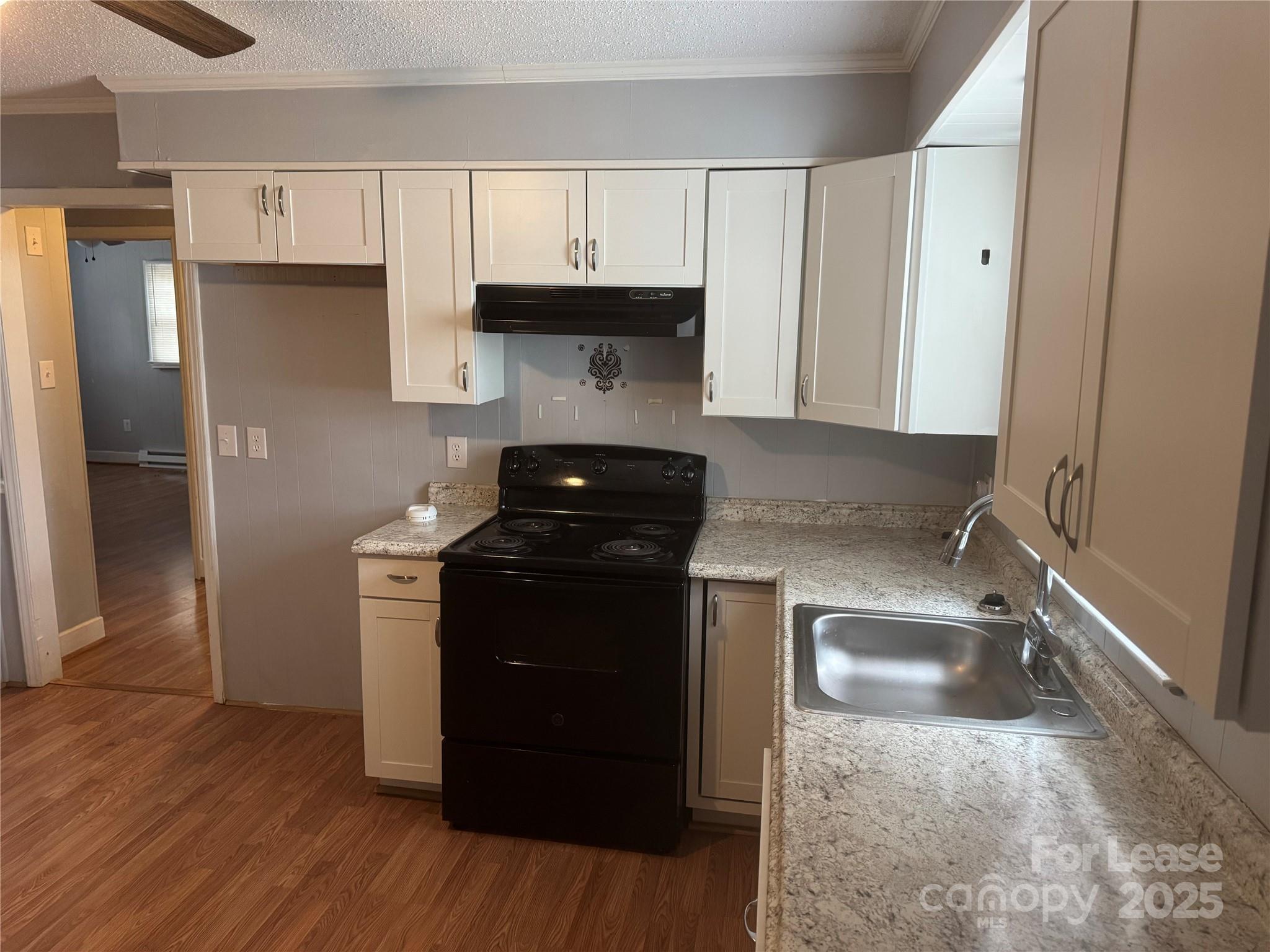 112 Chaney Street Wingate, NC 28174 - Photo 3 of 7 a kitchen with a sink a stove and refrigerator