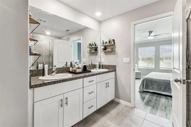 a en suite bathroom with a granite countertop tub shower and sink