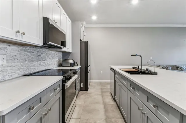 a kitchen with stainless steel appliances a sink stove and microwave