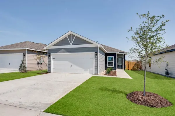 a front view of a house with a yard and trees