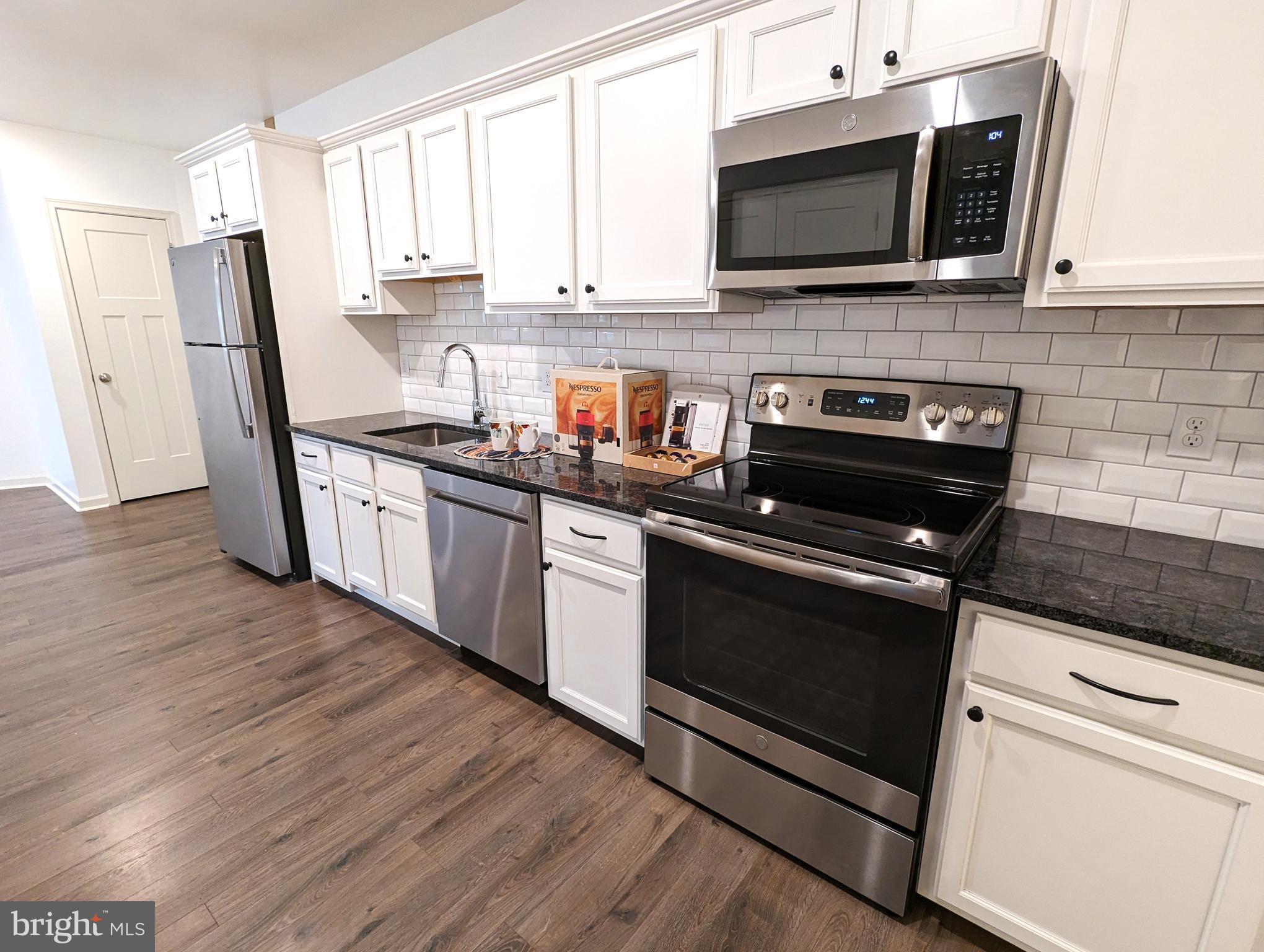 5420 Ridge Avenue, Unit 104 Philadelphia, PA 19128 - Photo 1 of 7 a kitchen with stainless steel appliances a stove microwave and sink