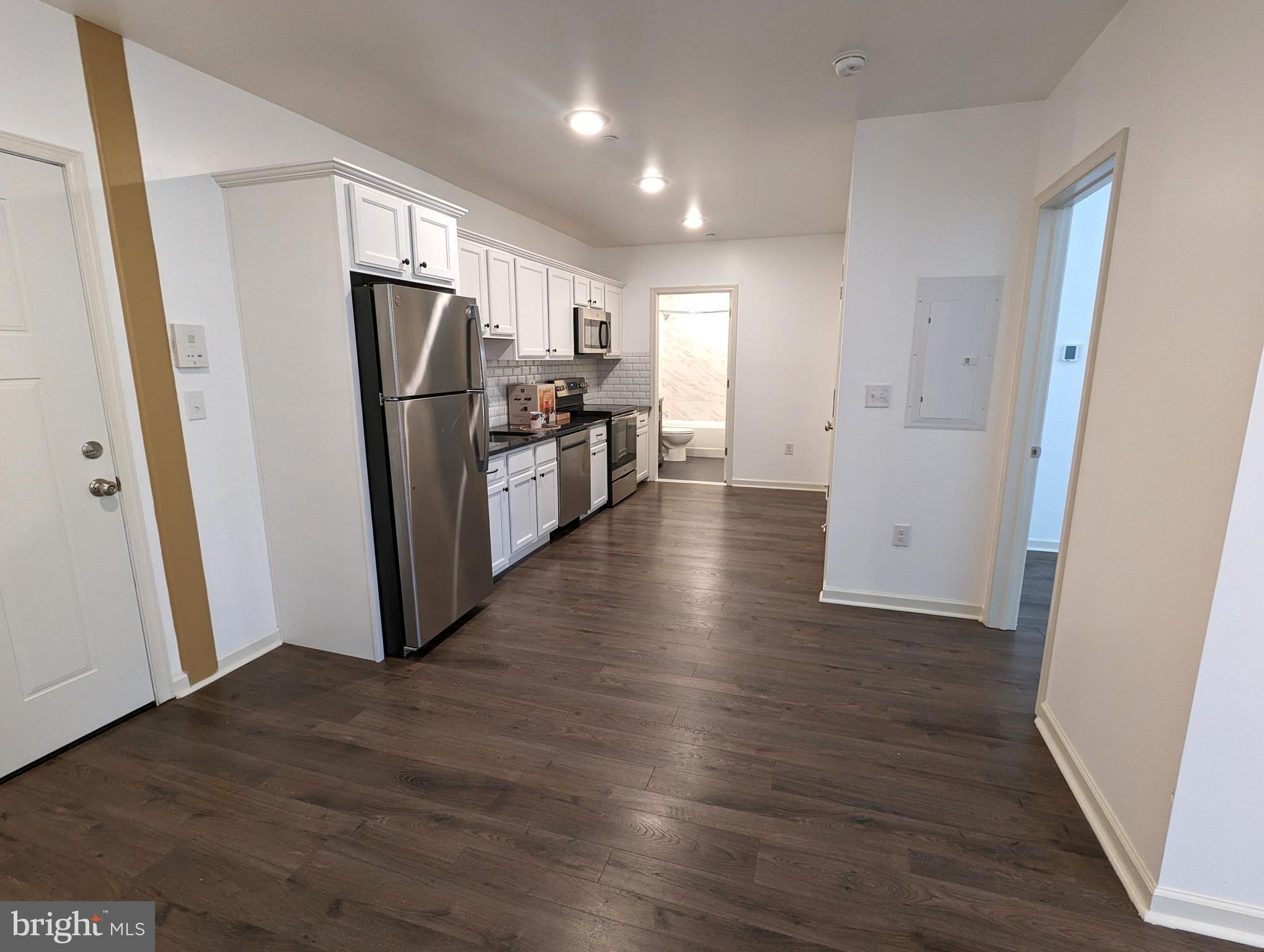 5420 Ridge Avenue, Unit 104 Philadelphia, PA 19128 - Photo 2 of 7 a view of a refrigerator in kitchen and wooden floor