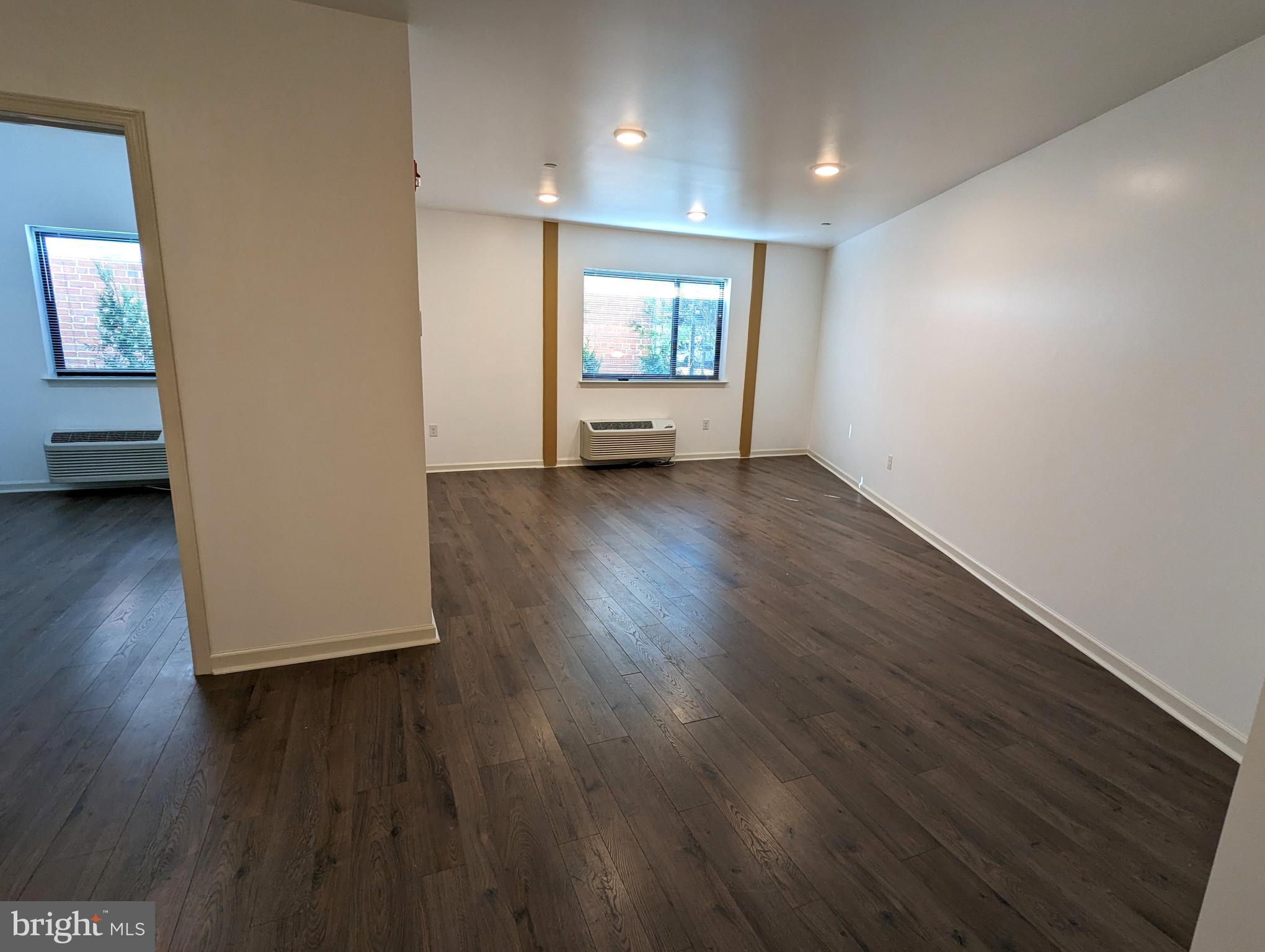 5420 Ridge Avenue, Unit 104 Philadelphia, PA 19128 - Photo 3 of 7 a view of an empty room with wooden floor and a window