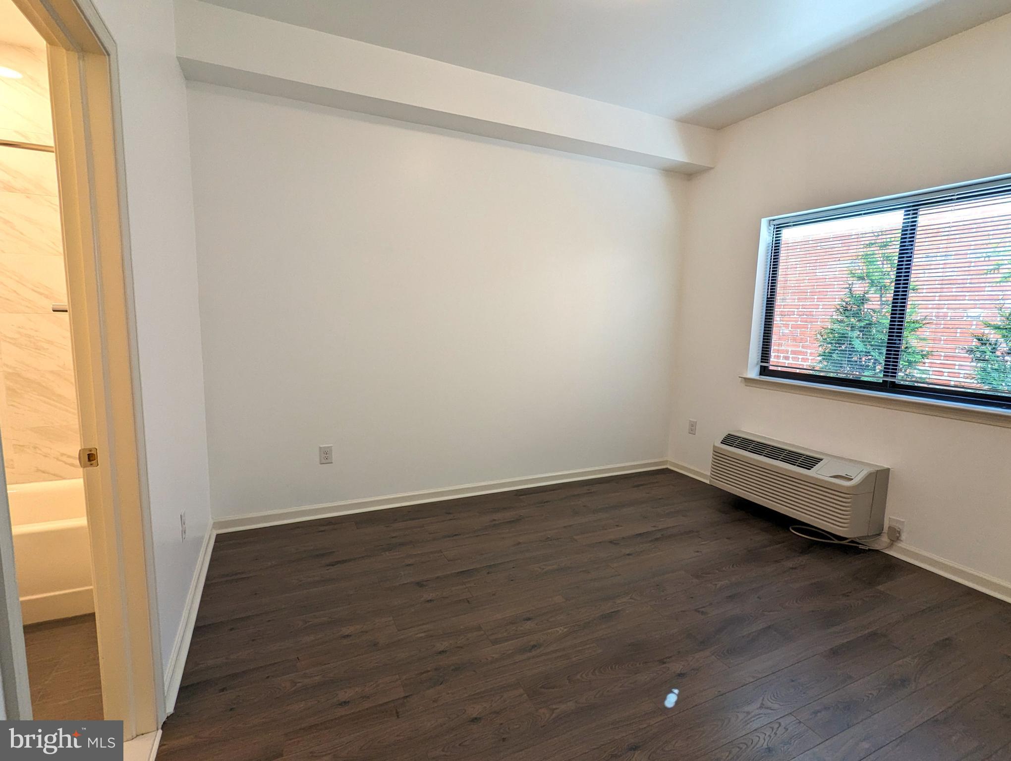 5420 Ridge Avenue, Unit 104 Philadelphia, PA 19128 - Photo 4 of 7 an empty room with wooden floor and windows