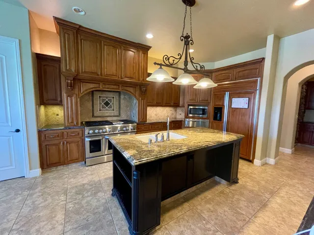 a kitchen with stainless steel appliances granite countertop a stove and a sink