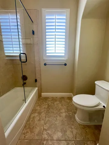 a bathroom with a toilet and a shower