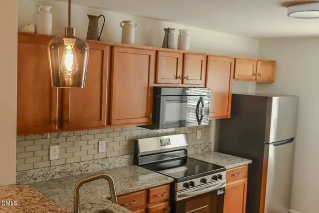 a kitchen with stainless steel appliances granite countertop a refrigerator sink and stove
