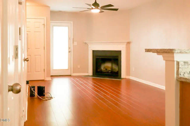 a view of empty room with a fireplace and wooden floor
