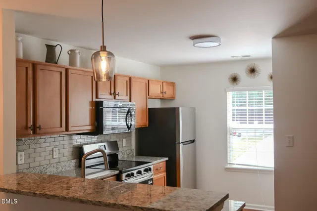 a kitchen with stainless steel appliances granite countertop a refrigerator and a stove