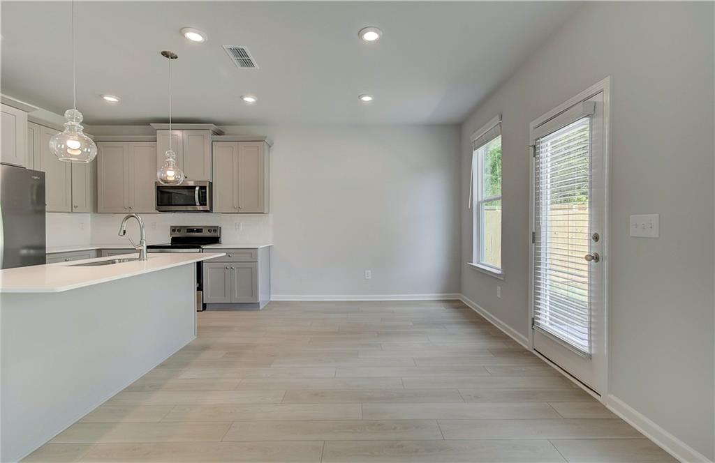 117 Alpine Road Fairburn, GA 30213 - Photo 11 of 29 a kitchen with a white wooden cabinets and white appliances