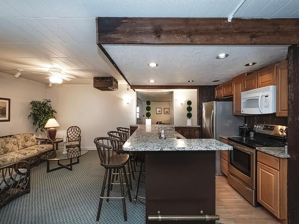 900 Washington Road, Unit 512 Pittsburgh, PA 15228 - Photo 27 of 29 a kitchen with stainless steel appliances kitchen island granite countertop a table chairs in it and wooden floors
