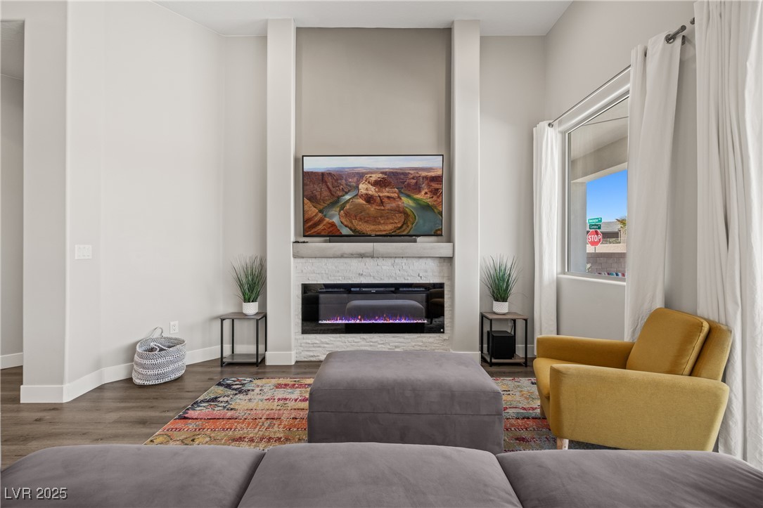 1357 Manassas Ridge Mesquite, NV 89027 - Photo 27 of 72 Living area featuring a glass covered fireplace, wood finished floors, and baseboards