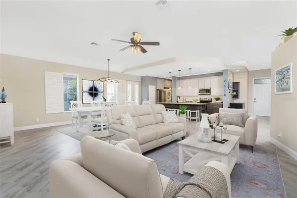a kitchen with a wooden floor a sink stainless steel appliances and cabinets