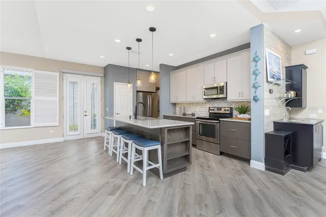 a kitchen with cabinets a sink appliances and a living room view