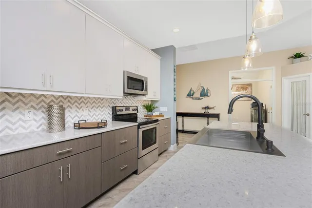 a kitchen with stainless steel appliances granite countertop a refrigerator a stove top oven a sink and dishwasher