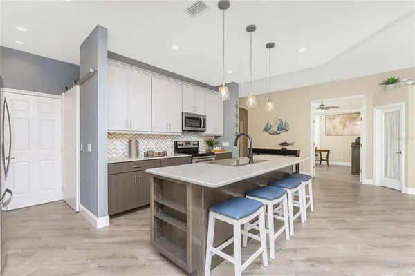 a kitchen with stainless steel appliances granite countertop a refrigerator a stove top oven a sink and dishwasher