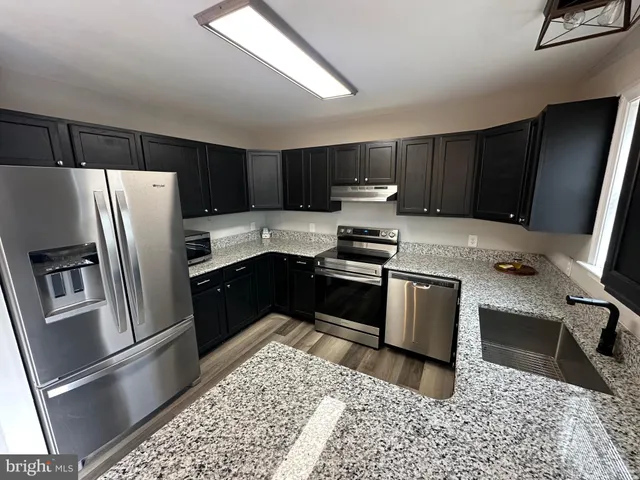 a kitchen with a refrigerator stove and sink