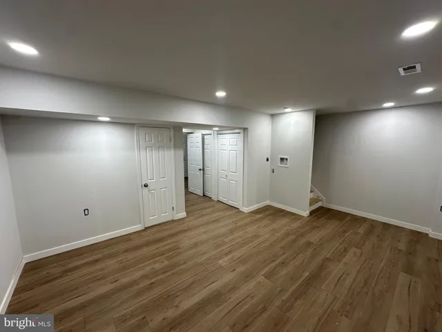 an empty room with wooden floor and window