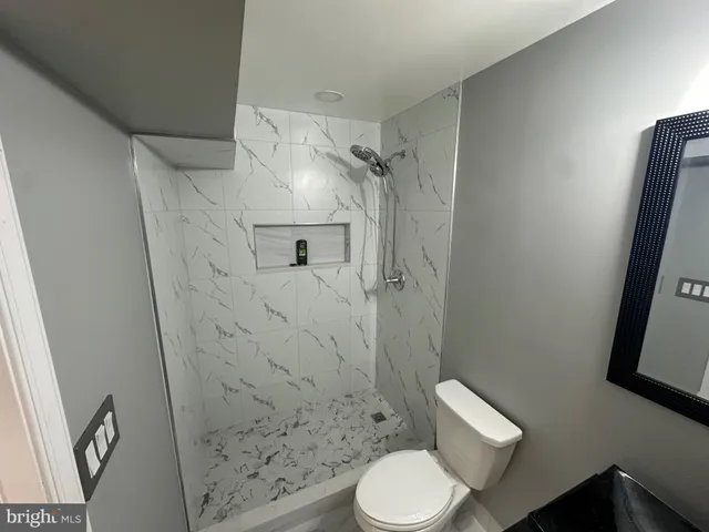 a white toilet sitting next to a bathroom sink and a shower