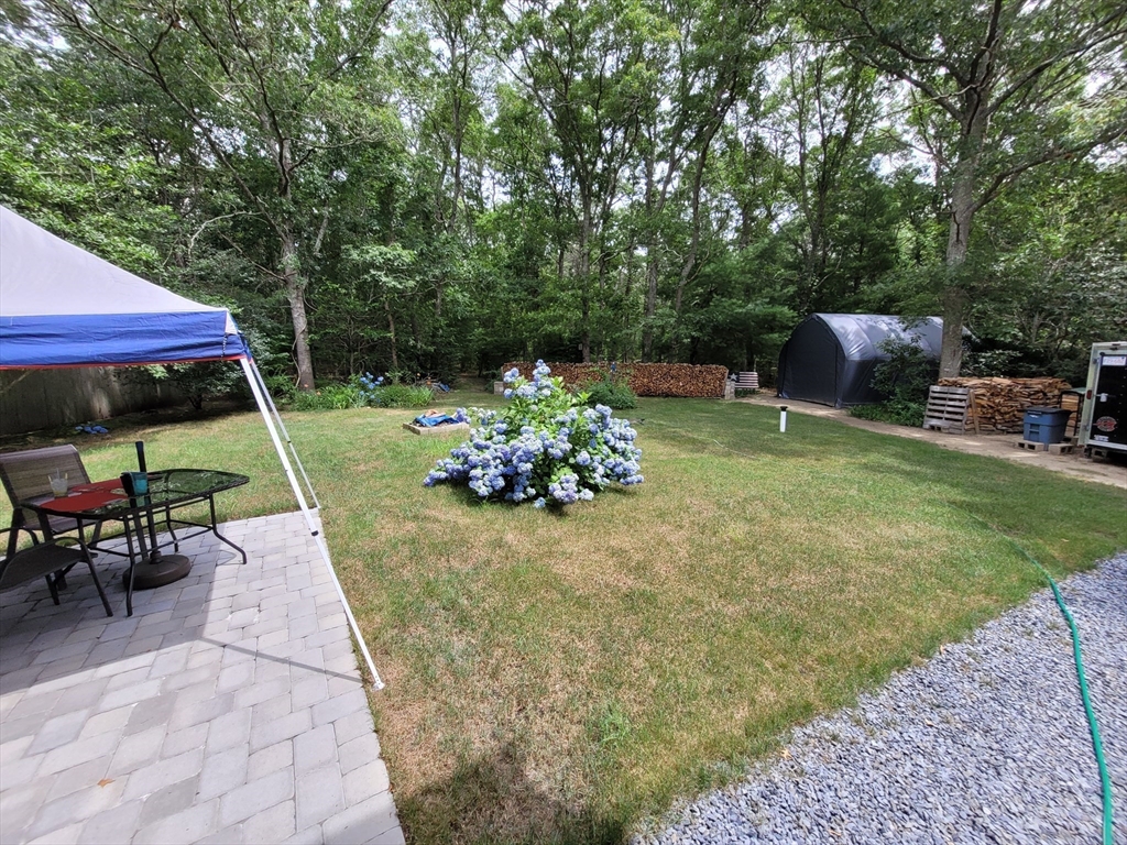 92 Santuit Pond Road Mashpee, MA 02649 - Photo 20 of 23 a view of a patio with furniture and a yard